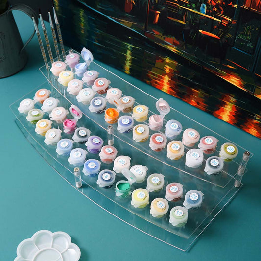 Set of small containers with colorful lids on a clear acrylic tray, with a blurred background.