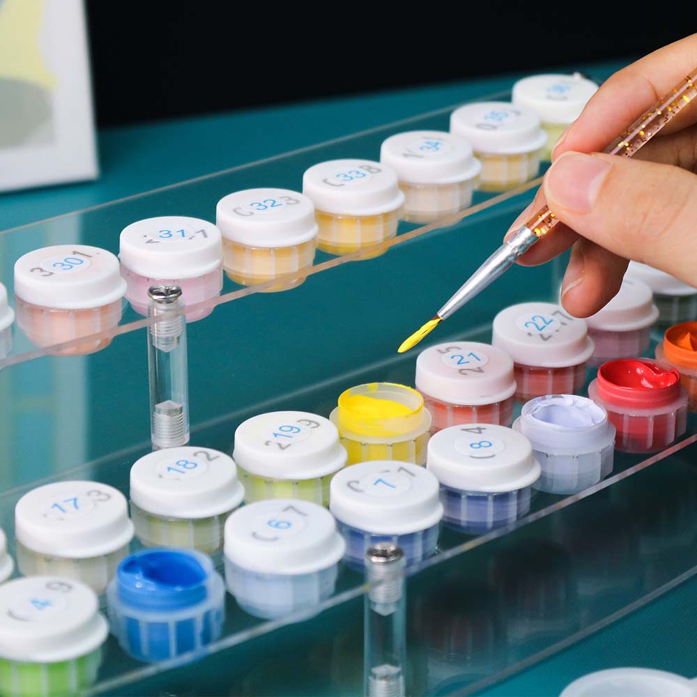 Person using a pipette to transfer liquid from one container to another on a rack.