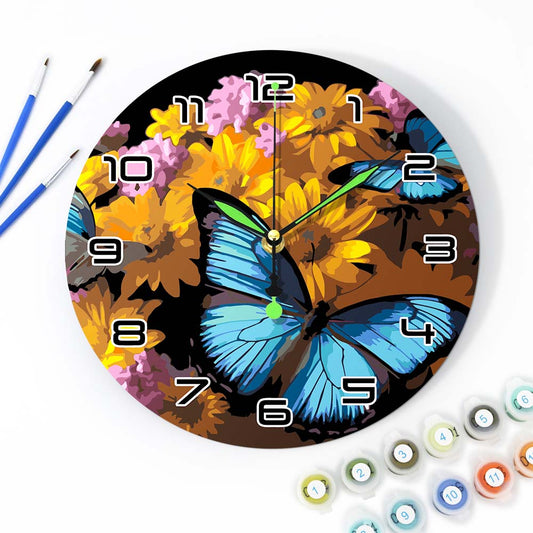 Decorative wall clock with butterfly and floral design, surrounded by art supplies.