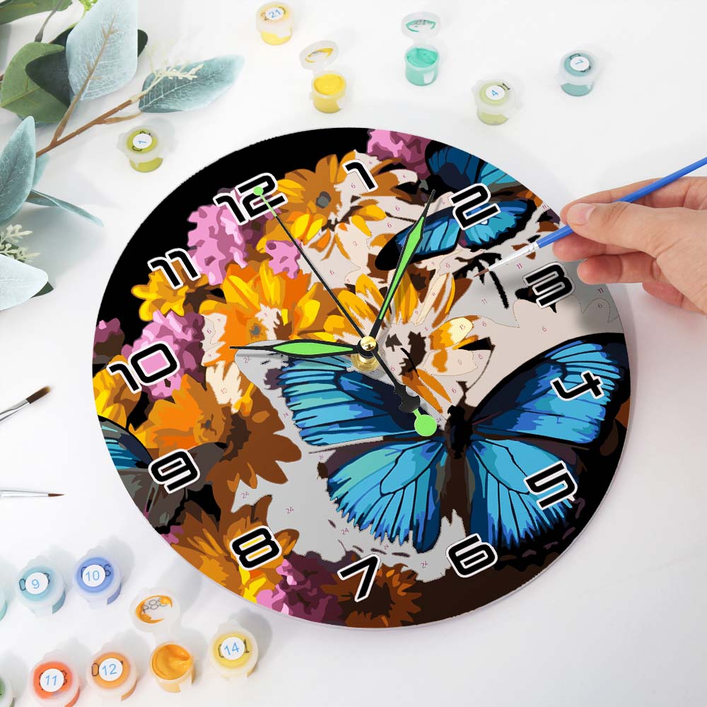 Painting a clock with colorful butterflies and flowers on a white surface.