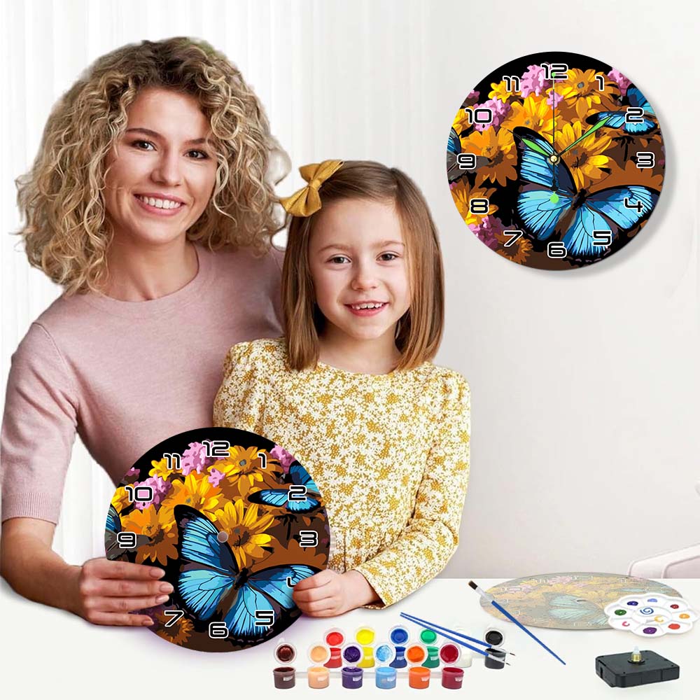 Woman and child holding butterfly-themed wall clocks with painting supplies on a table.