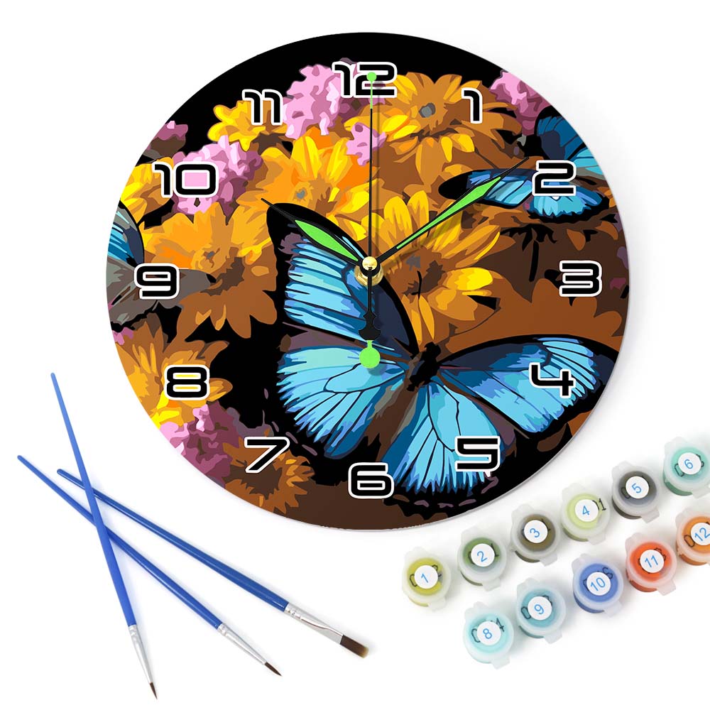 Decorative clock with butterfly and floral design, accompanied by paintbrushes and paint tubes.