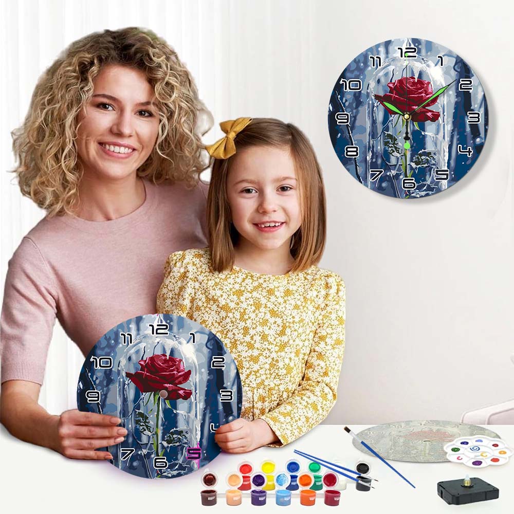 Woman and child holding a painted wall clock with a rose design, surrounded by art supplies.