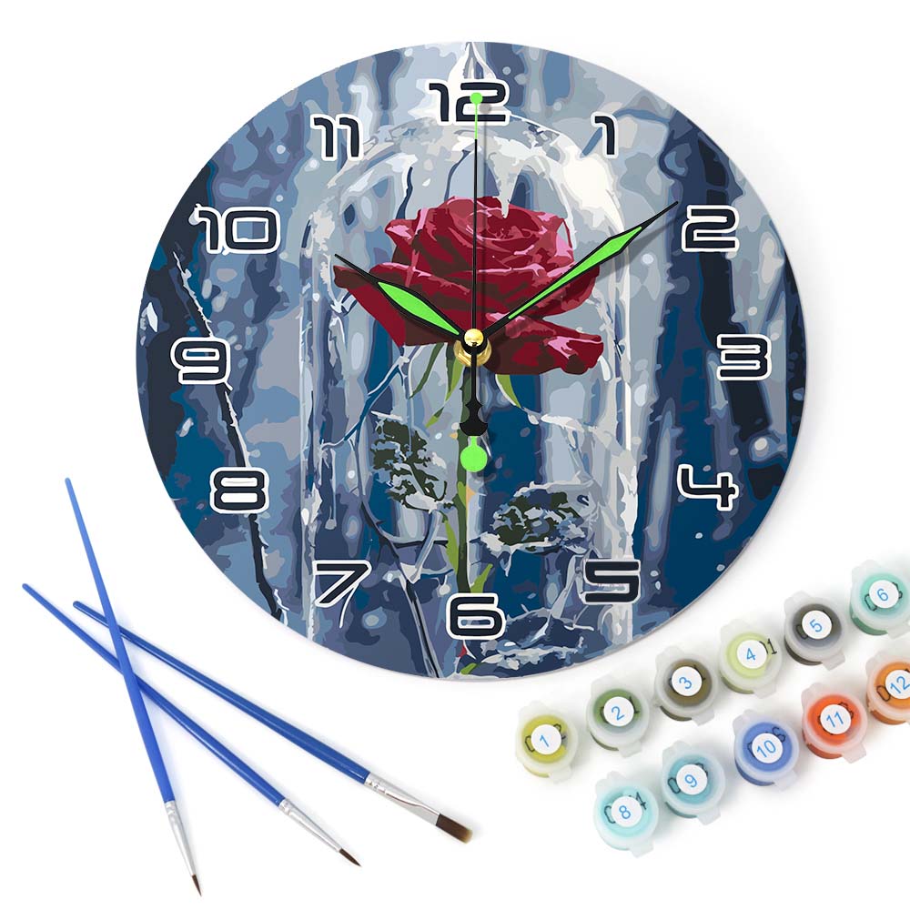 Decorative wall clock with a rose design, paintbrushes, and paint tubes on a white background