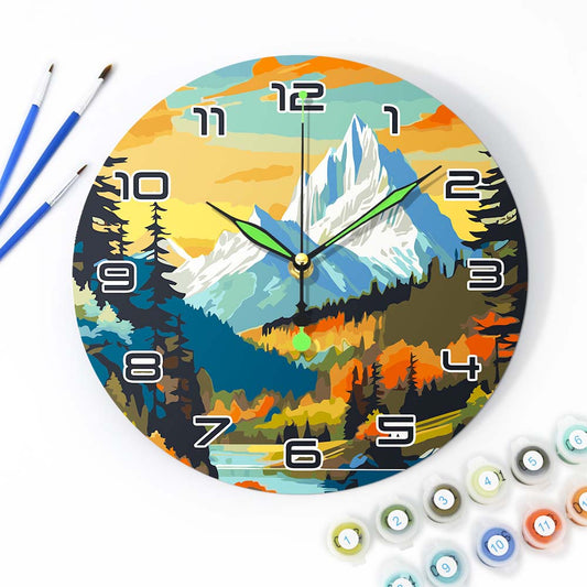 Colorful wall clock with mountain and forest design, surrounded by paintbrushes and paint tubes.