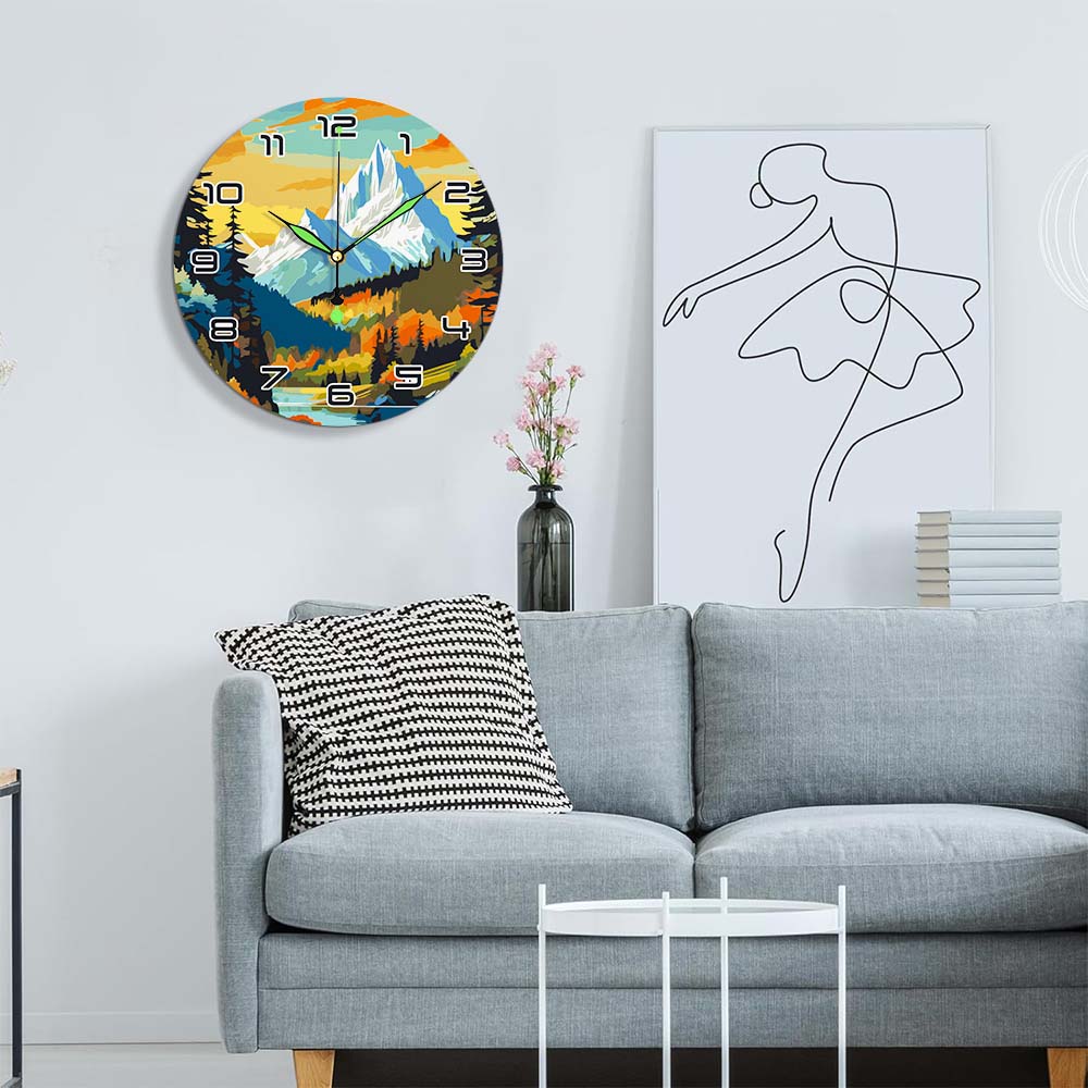 Living room with a gray sofa, decorative pillow, and wall clock featuring a mountain landscape.