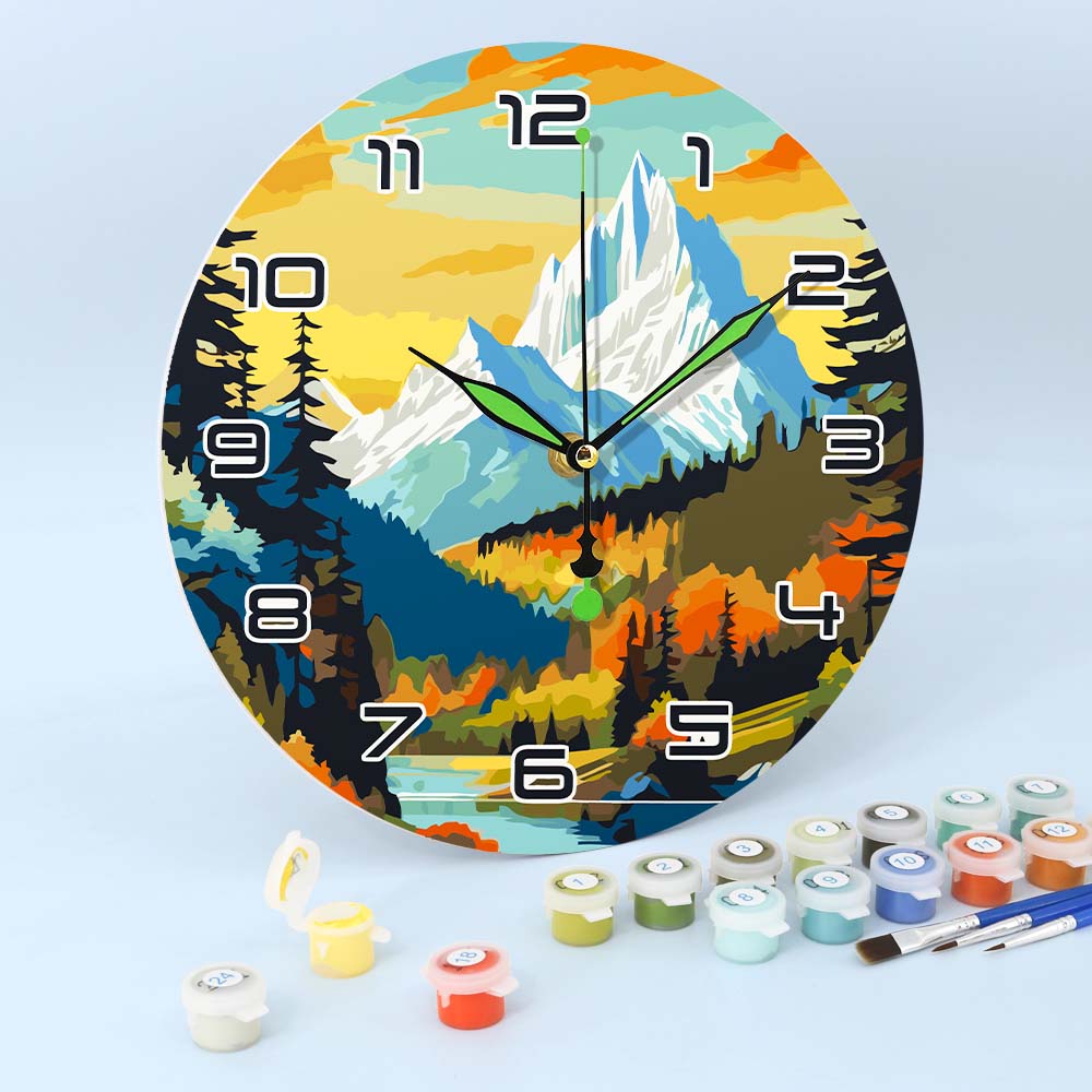 Decorative wall clock with mountain and forest design, surrounded by paint cans and brushes on a light blue background.
