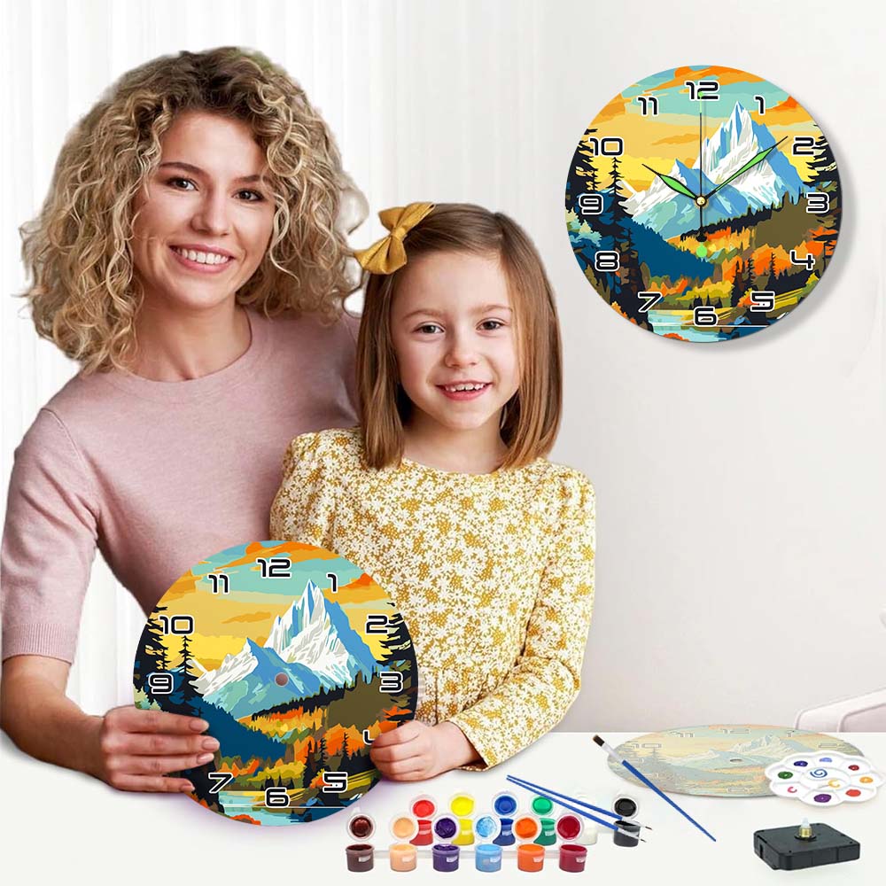 Woman and child holding a painted wall clock with mountain design, surrounded by art supplies.