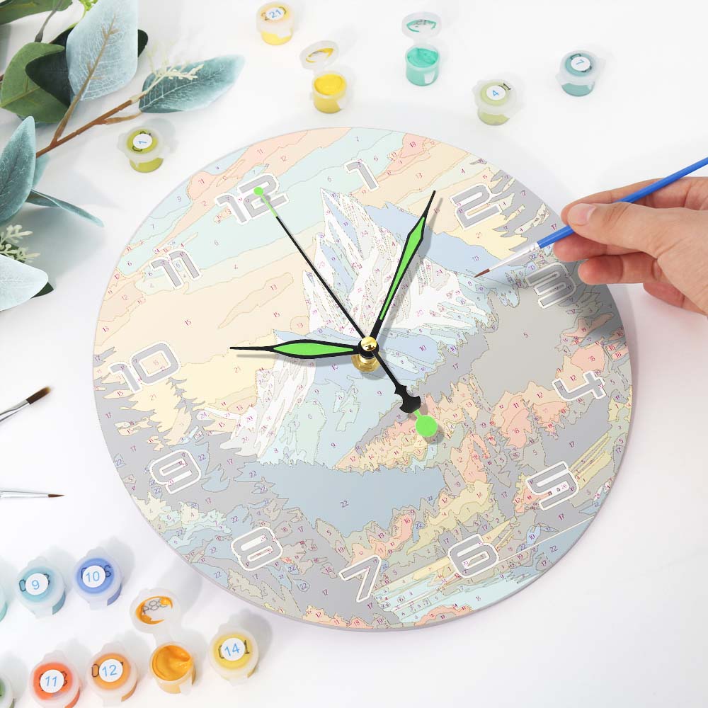 Person painting a round clock with various colors and tools on a white surface.