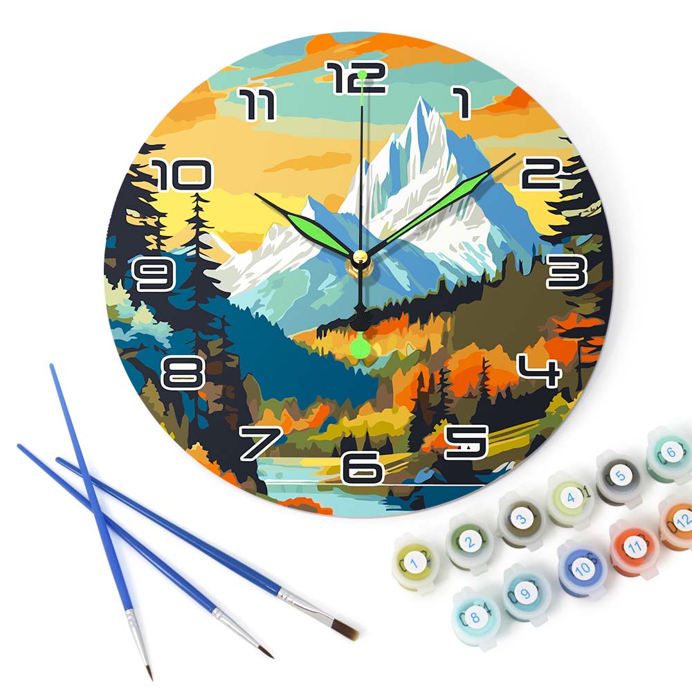 Decorative clock with mountain design, paintbrushes, and paint bottles on a white background