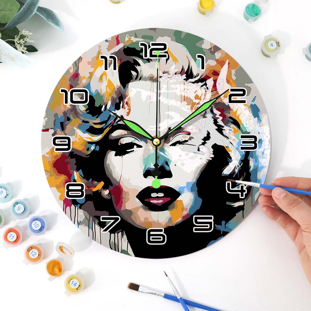 Colorful wall clock with artistic design of a face, surrounded by art supplies.