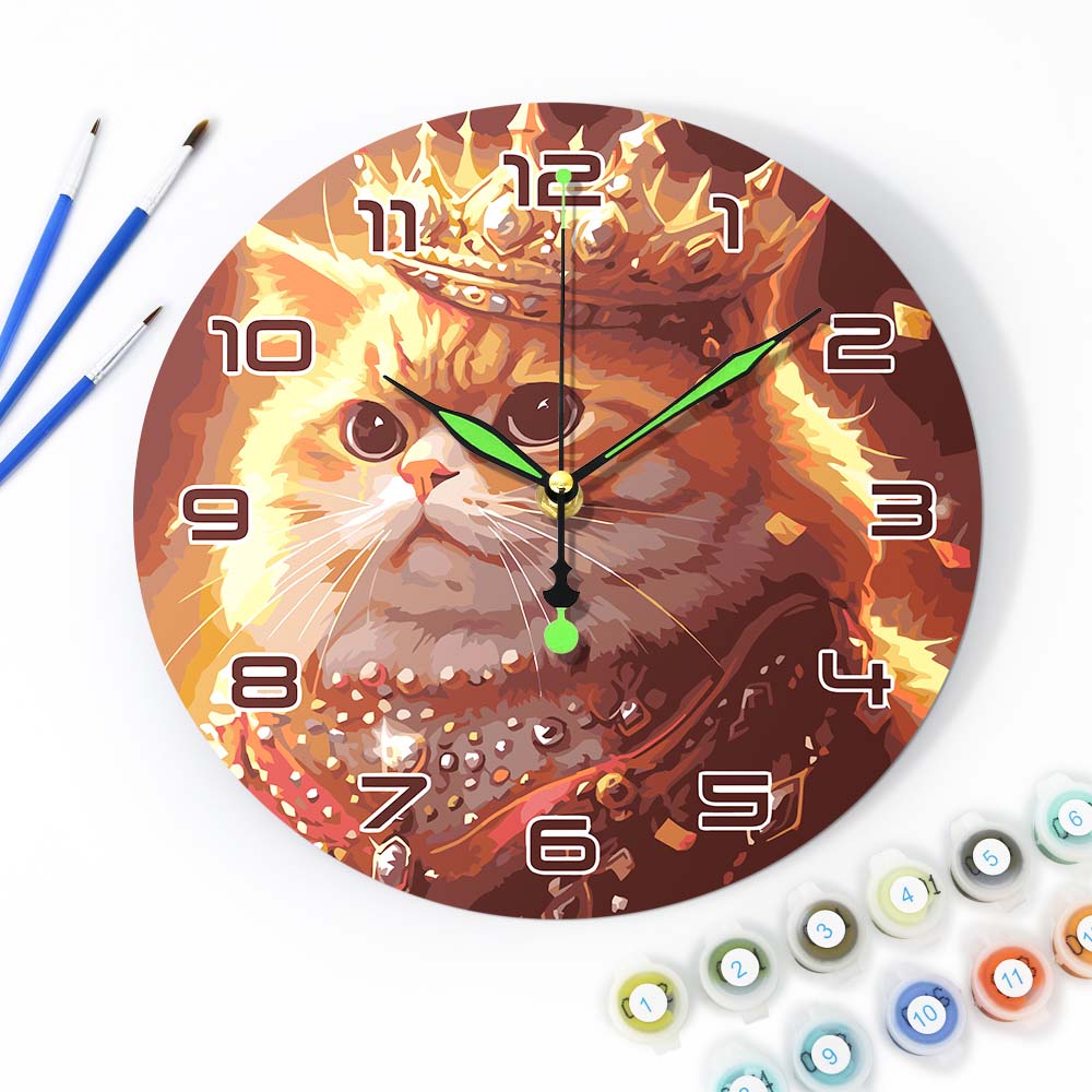 Wall clock with a cat design surrounded by art supplies on a white background