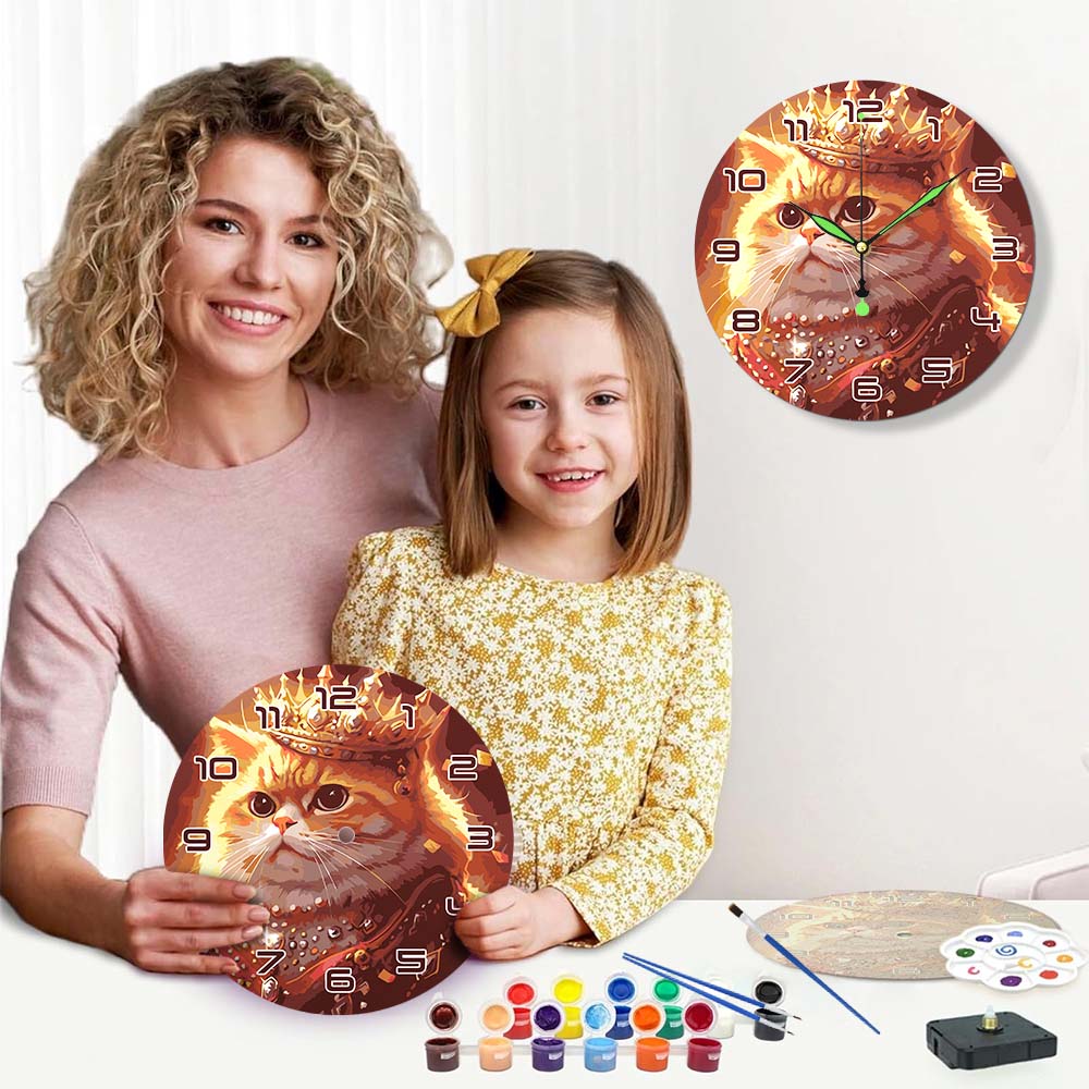 Woman and child holding cat-themed wall clocks with art supplies on a table.