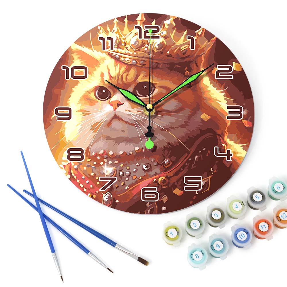 Decorative clock with a cat design, paintbrushes, and paint tubes on a white background