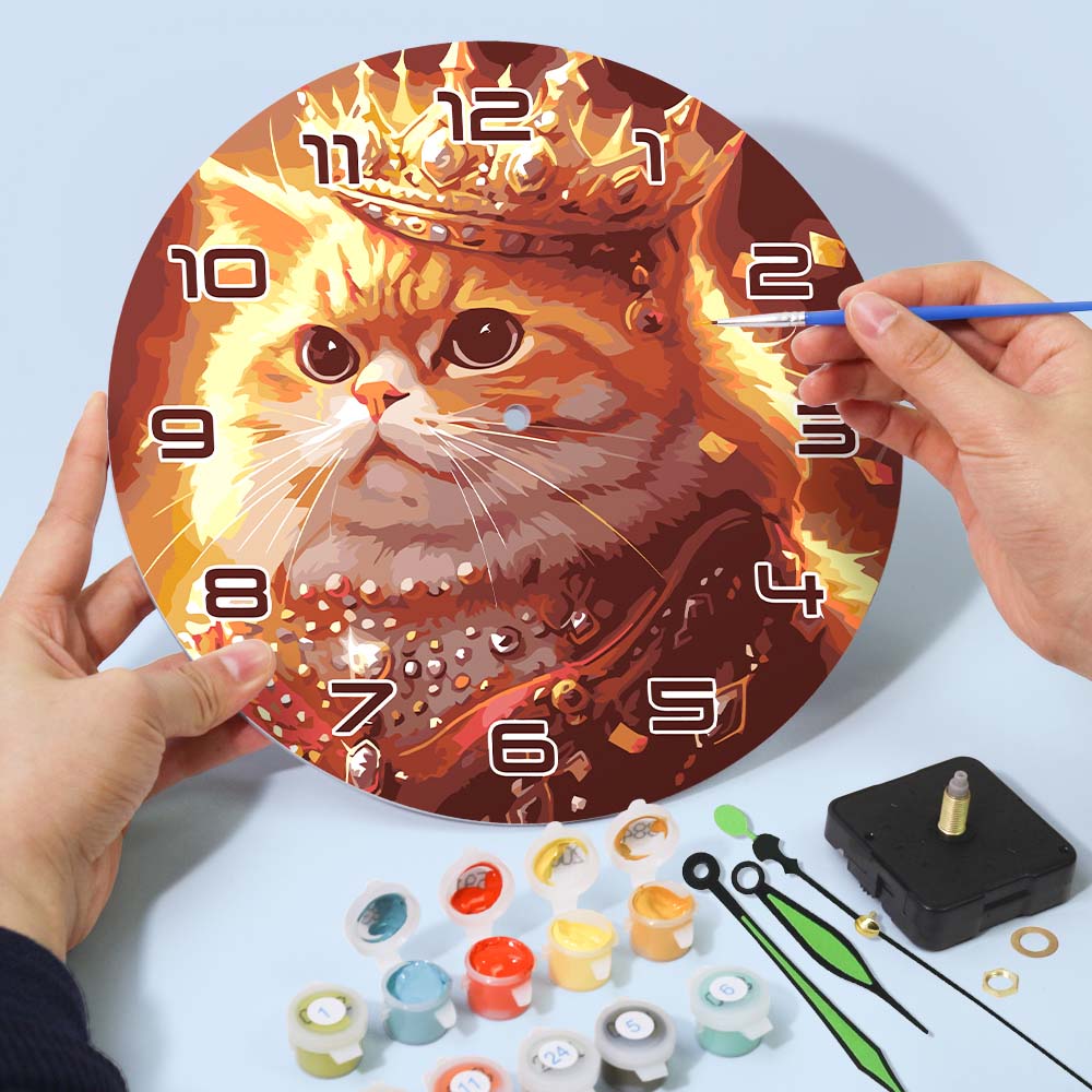 Painting a cat-themed clock with a hand holding a paintbrush and supplies on a light blue background.