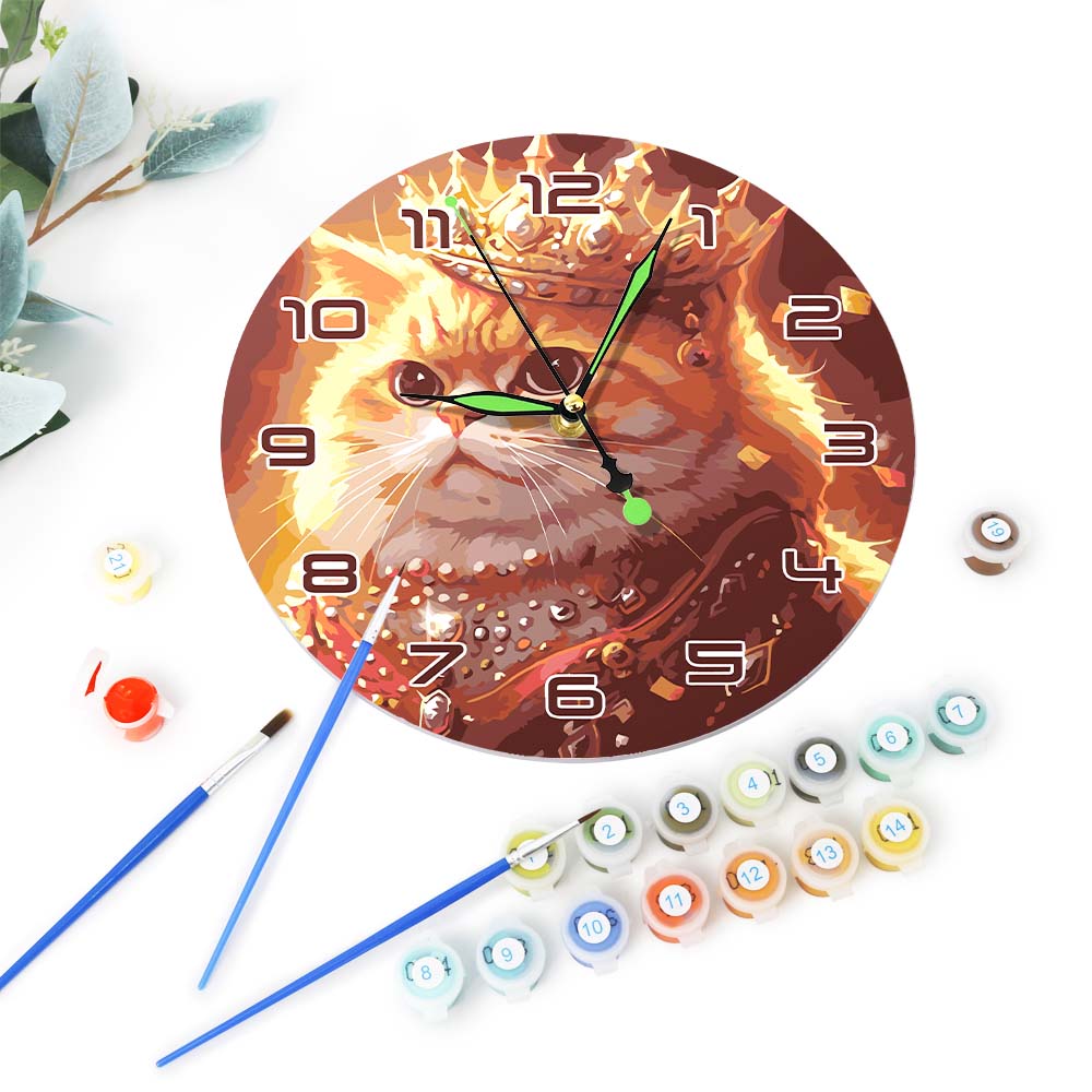Wall clock with a cat design surrounded by paint bottles and brushes on a white background