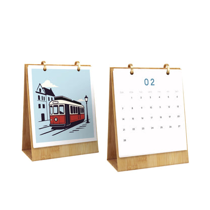 Two tabletop calendar stands on a white background, one showing an illustrated streetcar page and the other showing a blank numbered page with the number 02.