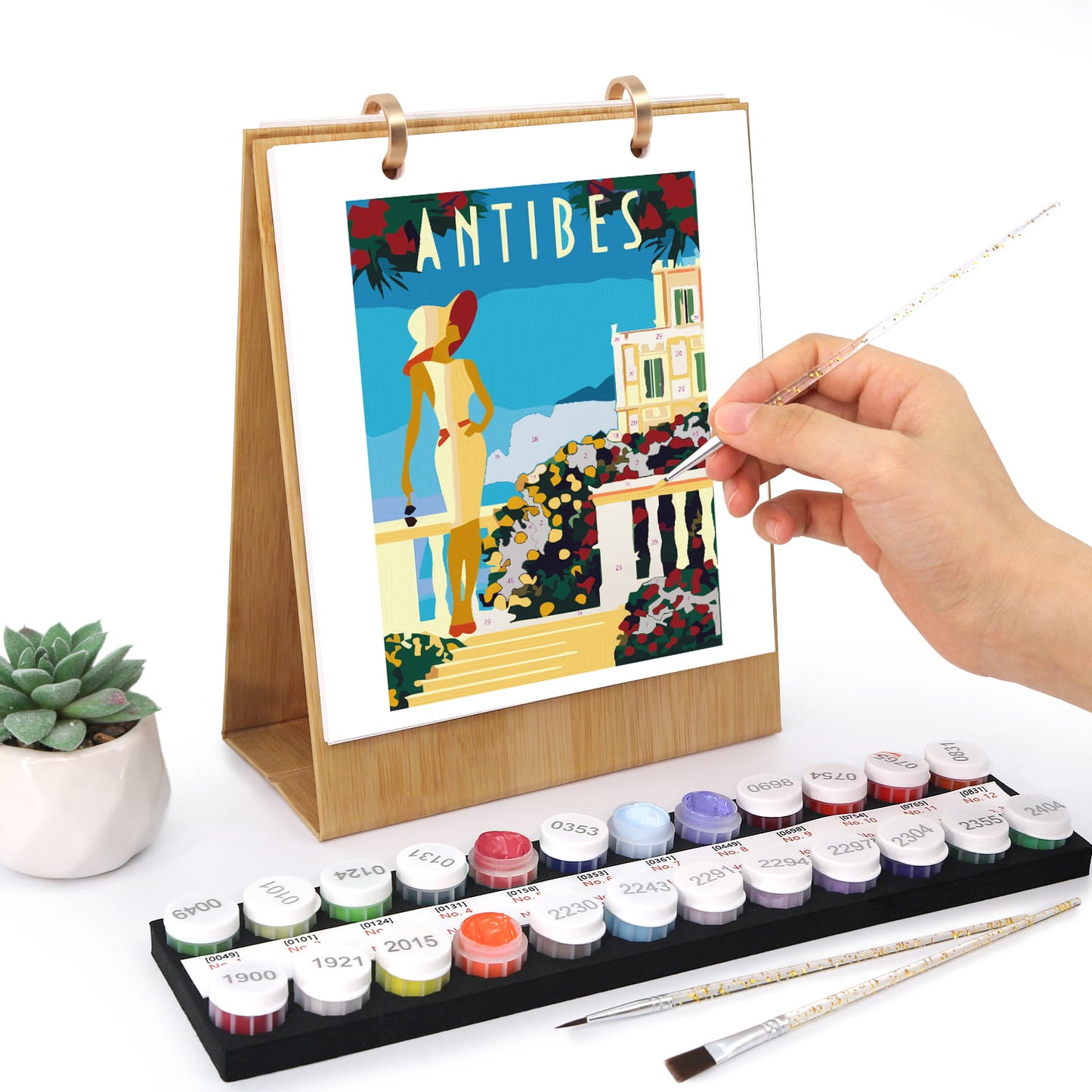 Artistic depiction of a scenic view with a person holding a paintbrush, surrounded by art supplies on a white background.