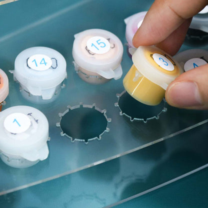 Hand selecting a labeled test tube from a rack with numbered containers.