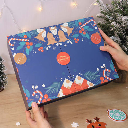 Advent calendar with Christmas-themed design held by hands on a wooden surface.