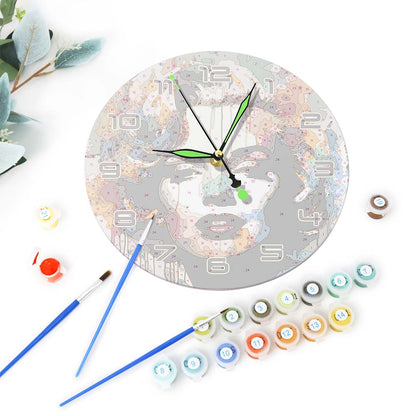 Decorative wall clock with paint bottles and brushes on a white background