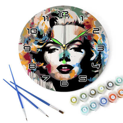 Decorative wall clock with artistic design, paintbrushes, and paint cans on a white background