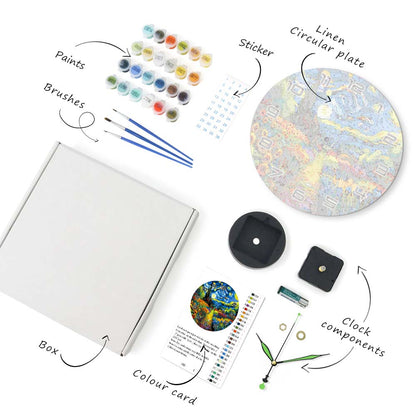 Artistic supplies including paints, brushes, a box, a color card, a clock, and a linen circular plate on a white background.