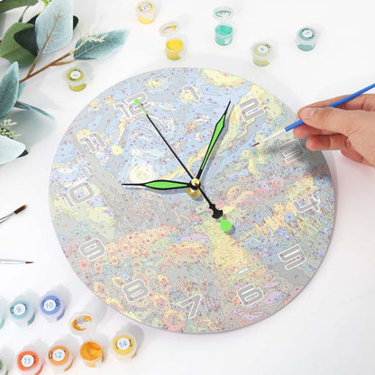 Person painting a round clock with colorful paint on a white surface.